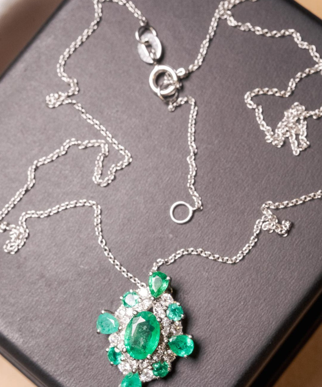 Colar Cartier em ouro branco com diamantes e esmeraldas.