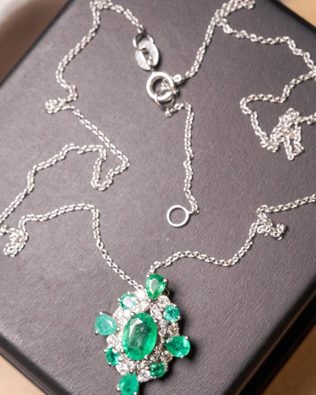 Colar Cartier em ouro branco com diamantes e esmeraldas.