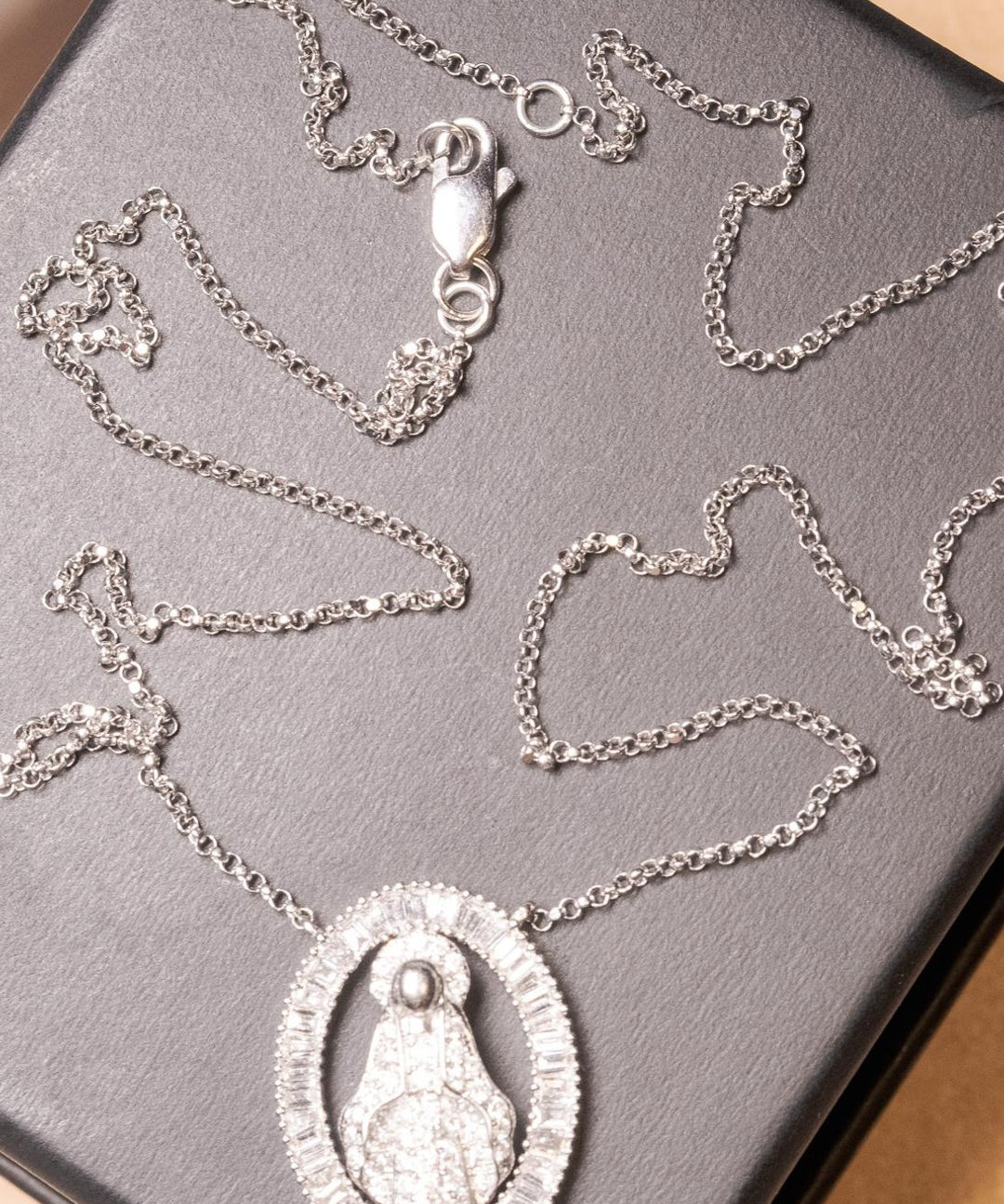 Colar de ouro branco com pingente de Nossa Senhora Aparecida e diamantes baguete e brilhante.