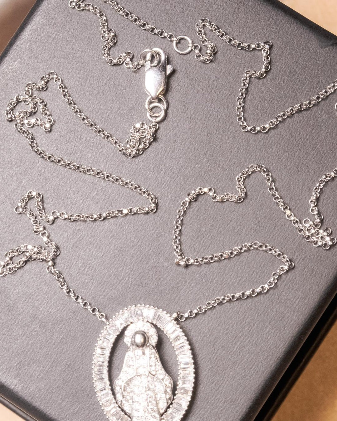 Colar de ouro branco com pingente de Nossa Senhora Aparecida e diamantes baguete e brilhante.