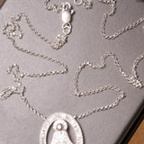 Colar de ouro branco com pingente de Nossa Senhora Aparecida e diamantes baguete e brilhante.