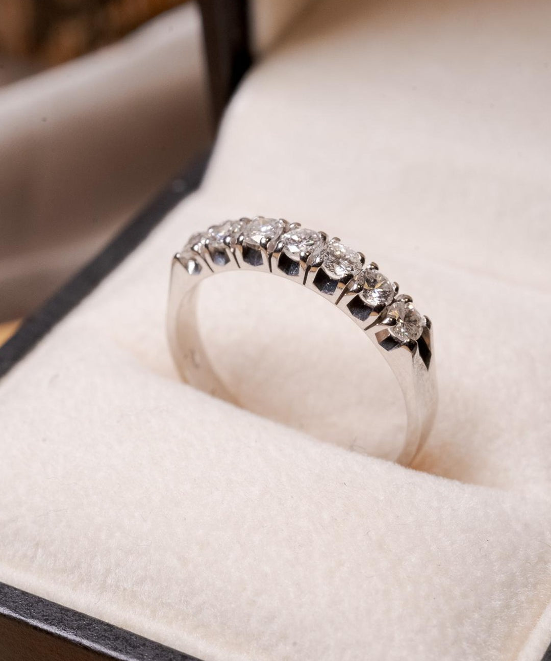 Anel meia aliança Sophí em ouro branco com 7 diamantes de 0.8 pontos e peso de 3.3g.