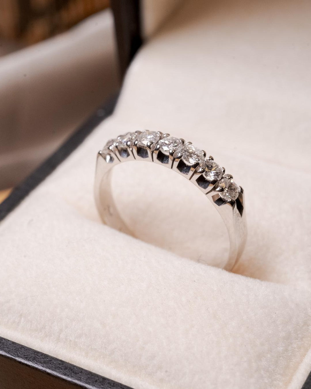 Anel meia aliança Sophí em ouro branco com 7 diamantes de 0.8 pontos e peso de 3.3g.