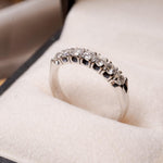 Anel meia aliança Sophí em ouro branco com 7 diamantes de 0.8 pontos e peso de 3.3g.