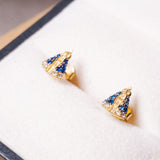 Brincos Stud de Nossa Senhora Aparecida em ouro amarelo com safiras azuis e brancas.