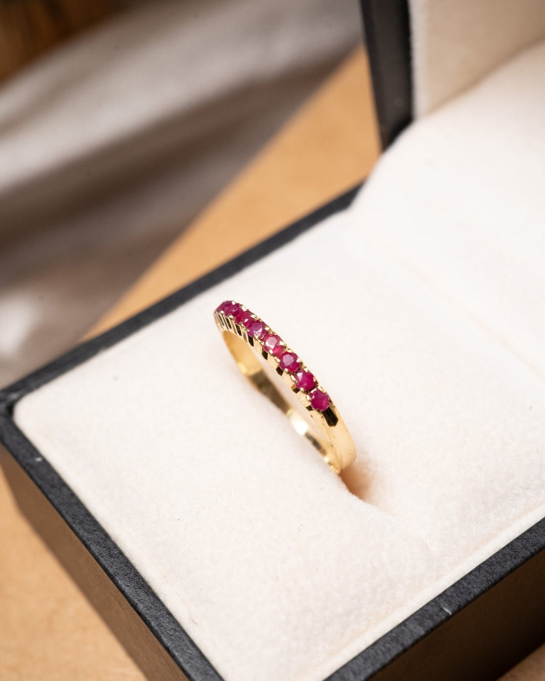 Anel meia aliança em ouro amarelo com 09 rubis naturais de 03 pontos cada. Base 0.3cm aro 16 peso 1.5 gramas.