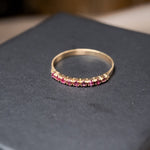 Anel meia aliança em ouro amarelo com 9 rubelitas naturais de 0.1ct cada. Base de 0.2cm. Aro 14.5. Peso 1.1g.