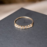 Anel meia aliança em ouro amarelo com 7 safiras brancas naturais de 0.3 pontos cada e base de 0.2cm.