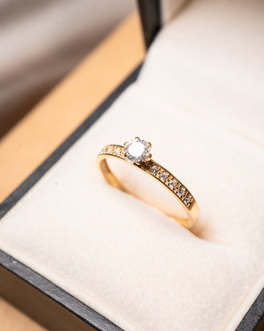 Anel solitário de ouro amarelo com topázio incolor de 0.25 quilates e peso de 1.7g.