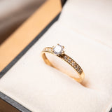 Anel solitário de ouro amarelo com topázio incolor de 0.25 quilates e peso de 1.7g.