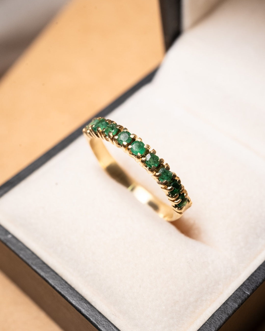 Anel meia aliança em ouro amarelo com 09 esmeraldas de 0.6 pontos cada e peso de 2.8g. Aro 25.