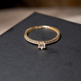 Anel solitário em ouro amarelo com safira central de 10 pontos e safiras laterais de 01 ponto. Peso 1.3g. Aro 16.