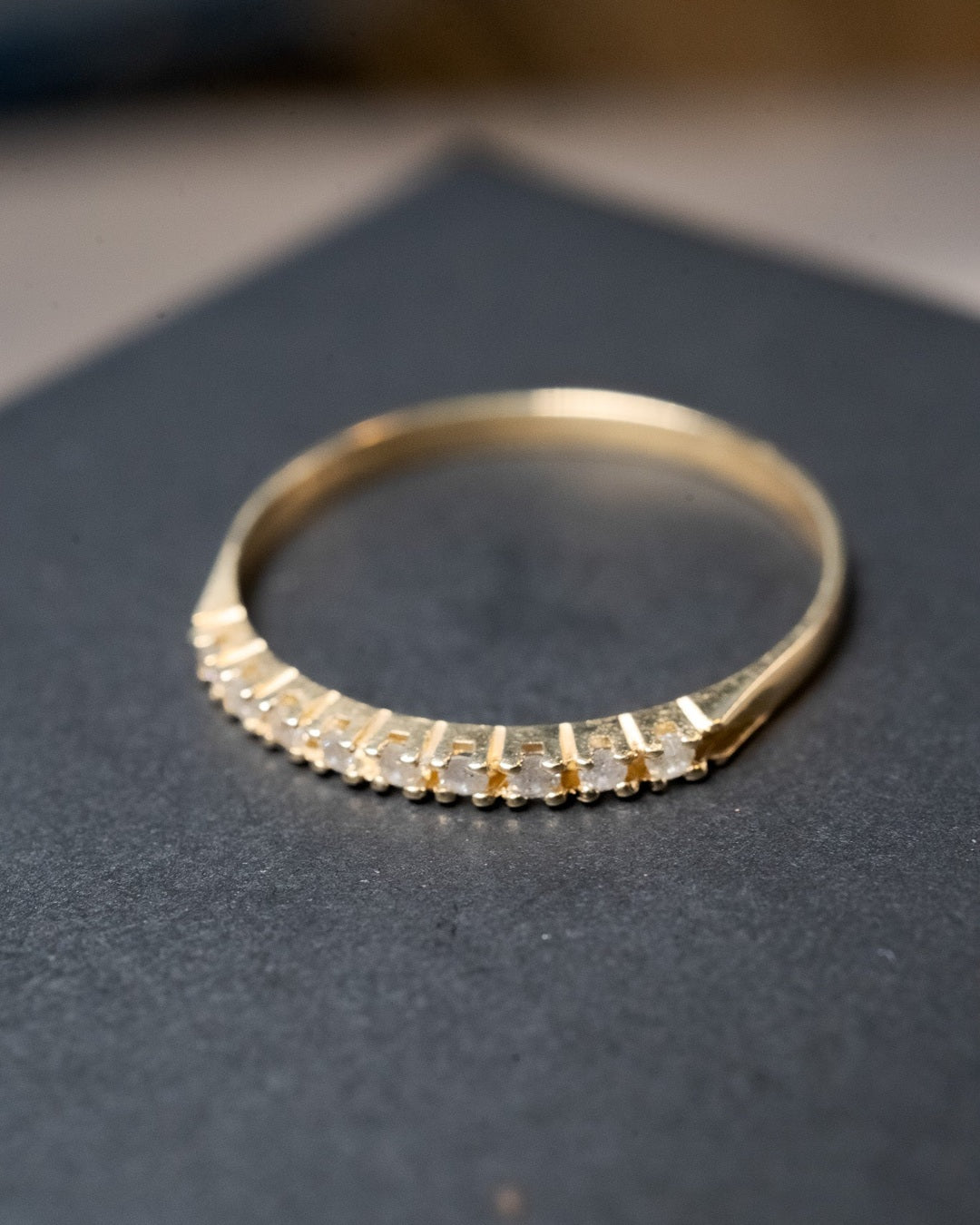 Anel meia aliança em ouro amarelo com 09 diamantes de 0.02 pontos. Peso 0.9g. Aro 18.