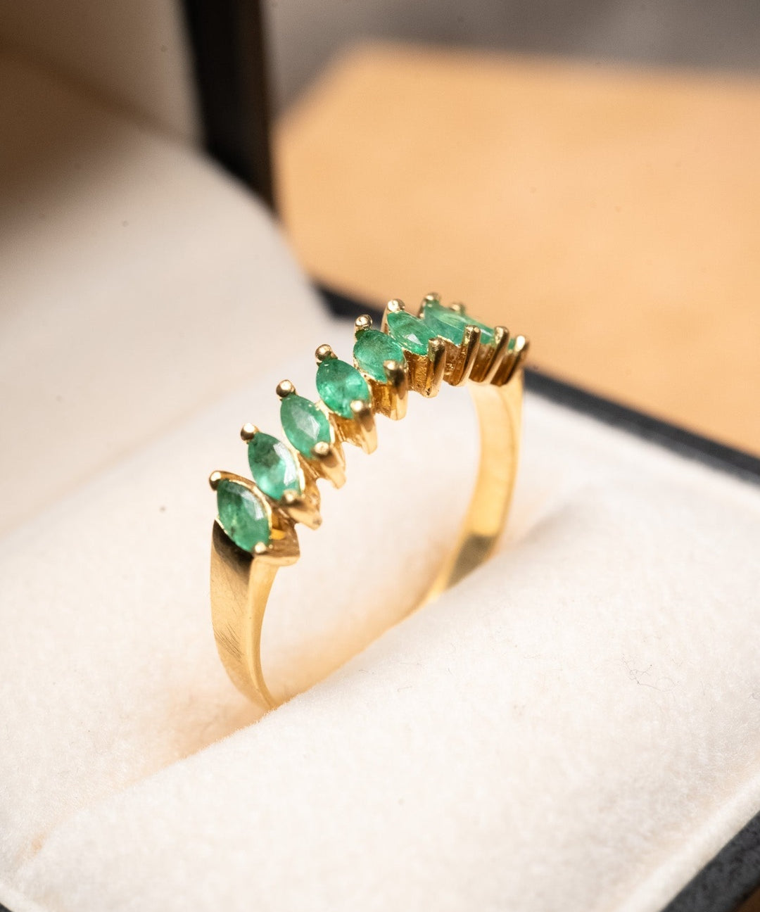 Anel meia aliança em ouro amarelo com 9 esmeraldas navette de 0.12ct cada e peso de 2.7g.
