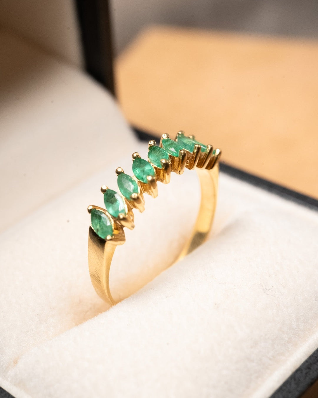 Anel meia aliança em ouro amarelo com 9 esmeraldas navette de 0.12ct cada e peso de 2.7g.