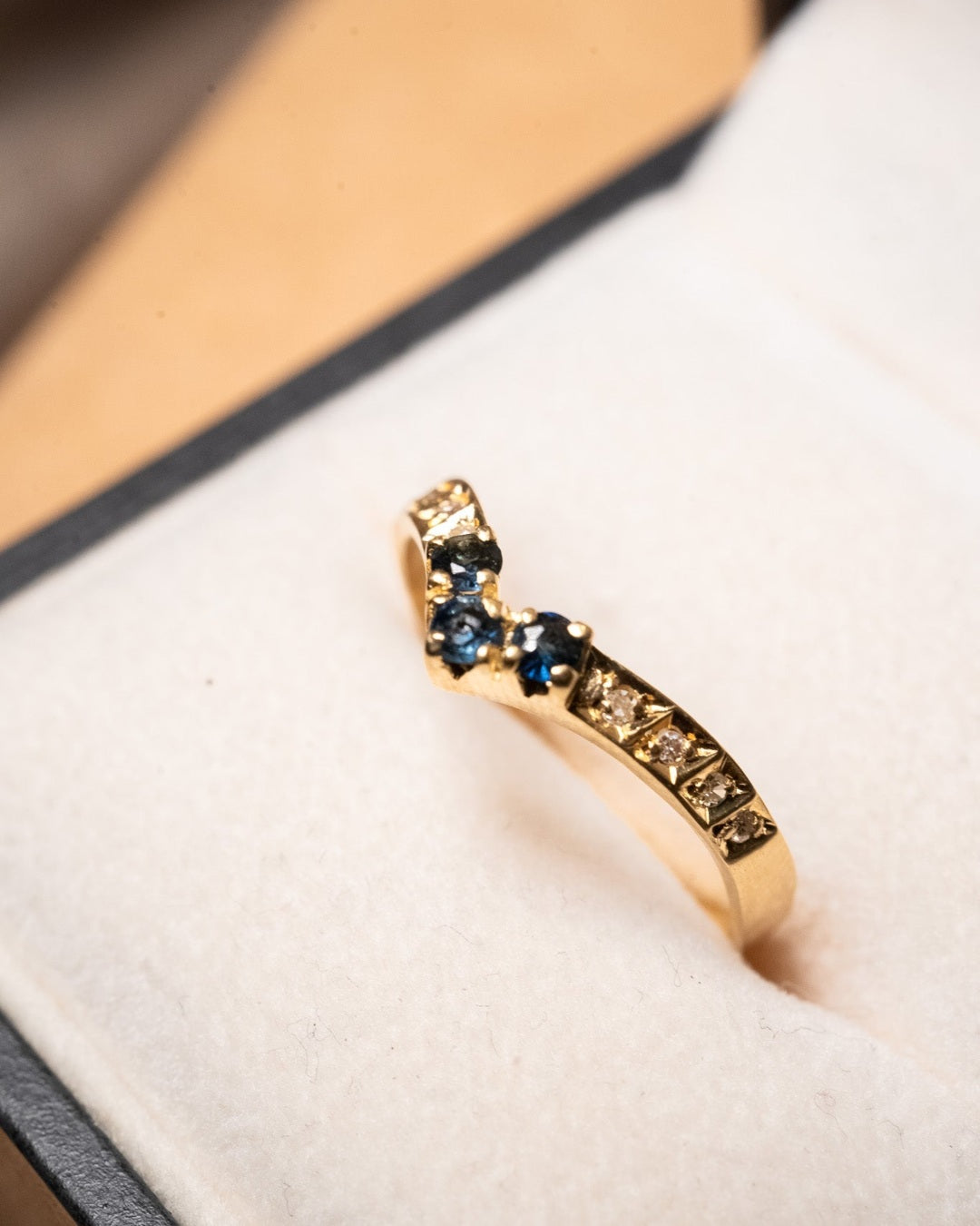 Anel moderno em ouro amarelo com 3 safiras azuis de 0.4 pontos e 8 diamantes de 0.1 ponto. Peso 1.9g. Aro 20.5.