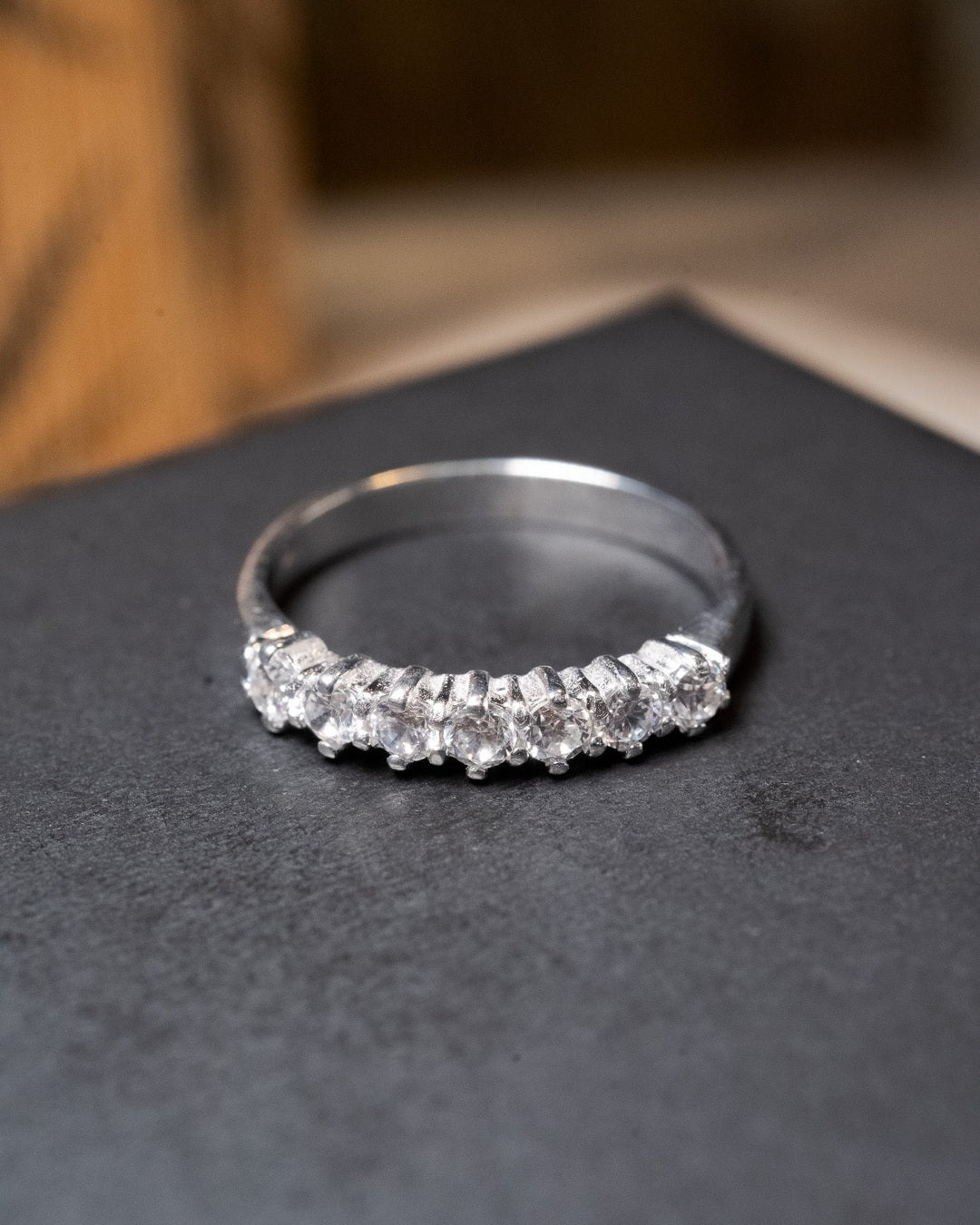 Anel meia aliança em ouro branco com 7 diamantes de 0.8 pontos e peso de 2.9g aro 16.