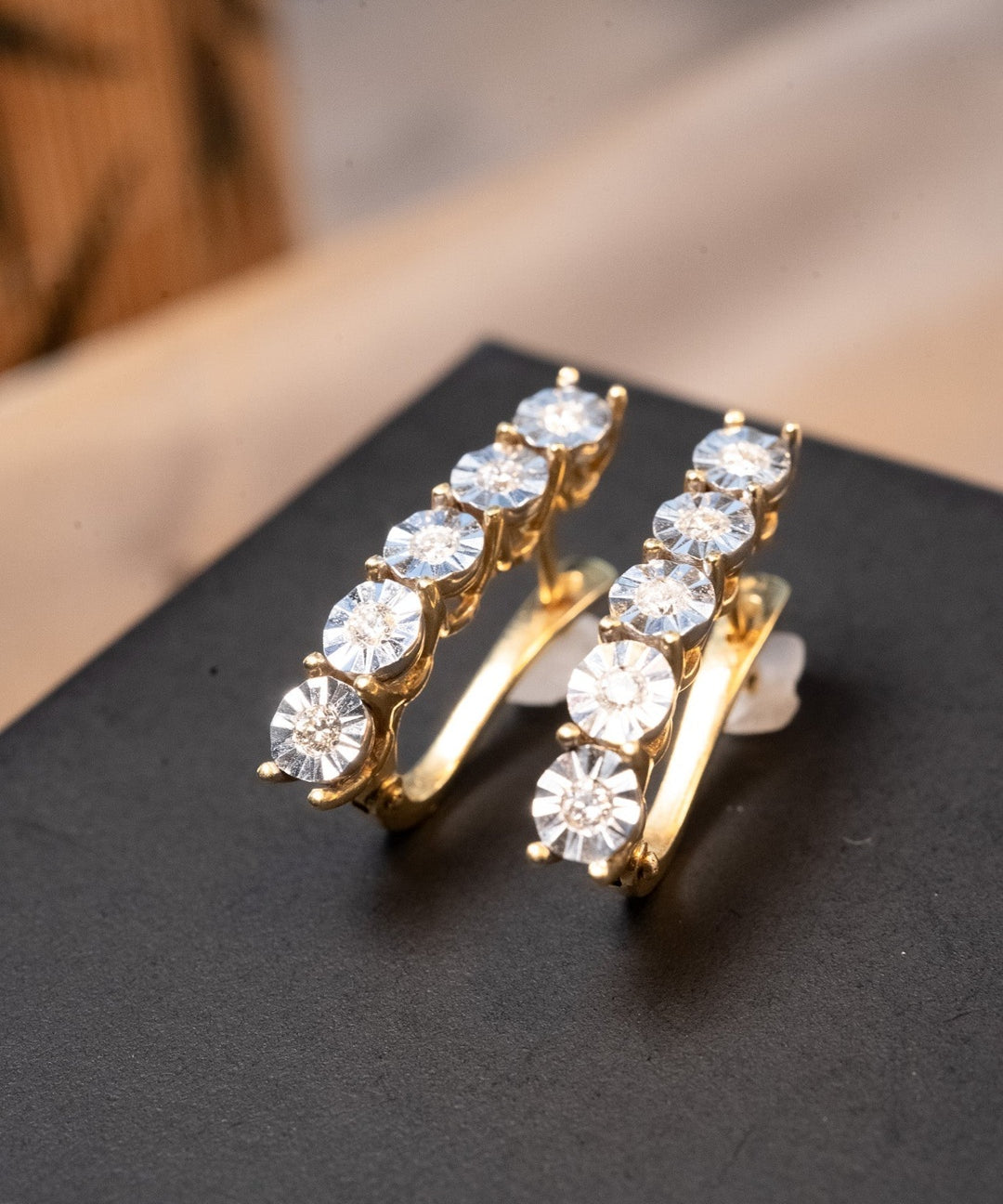 Brincos meia argola em ouro amarelo e branco com 10 diamantes de 0.3 pontos cada. Medem 2.4 x 0.4 cm e pesam 6.2 g.