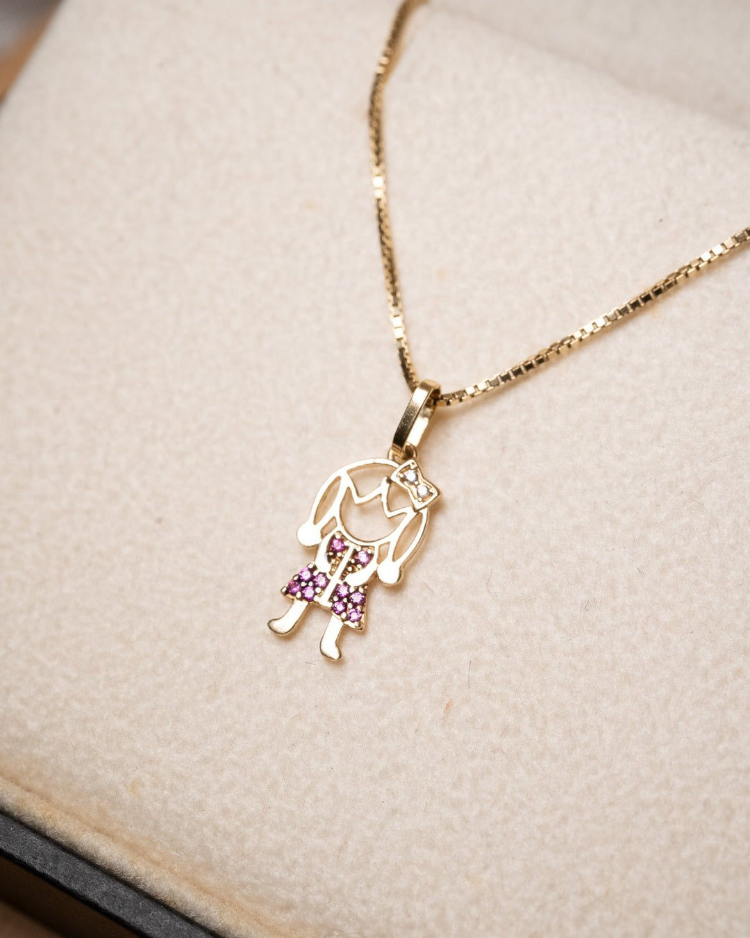 Pingente de menina em ouro amarelo com rubelitas e diamantes. Medidas 1.9 x 0.8 cm e peso 0.5g.