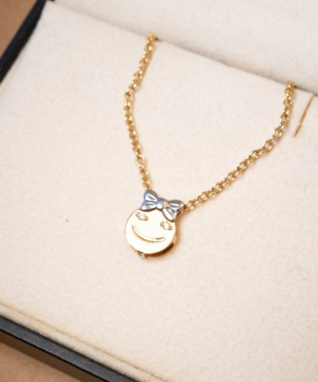 Pingente de menina em ouro amarelo com diamantes. Mede 1.3cm de altura e 1.0cm de largura. Peso de 0.7g.