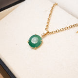 Pingente de ouro amarelo com esmeralda de 0.9x0.8cm e diamante. Medidas 1.7cm altura x 0.8cm largura. Peso 0.7g.