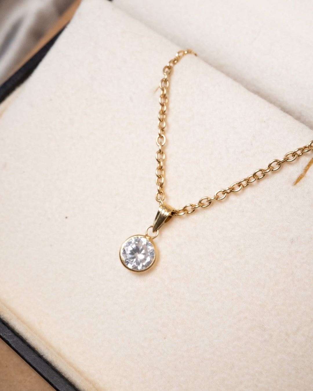 Pingente ponto de luz de ouro amarelo com safira branca. Medidas 1.3cm x 0.6cm e peso 0.4g.