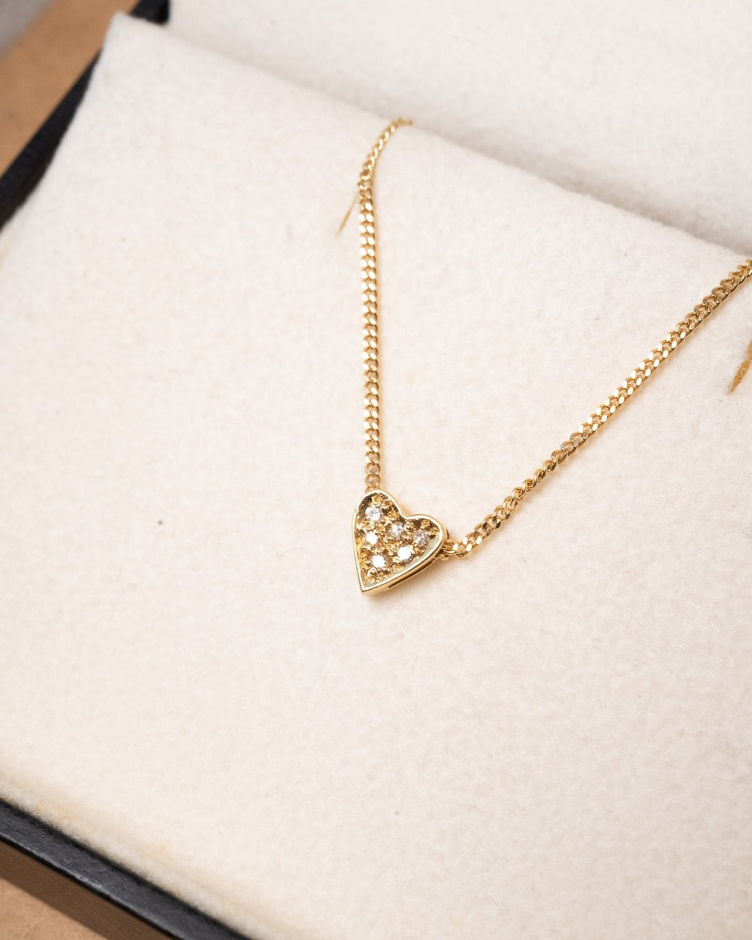 Pingente coração de ouro amarelo cravejado de diamantes. Diâmetro 0.7cm e peso 0.5g.