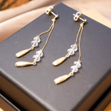 Brincos pendentes de ouro amarelo com cristais transparentes. Medem 6.0cm de altura e 0.4cm de largura. Peso 2.0g.