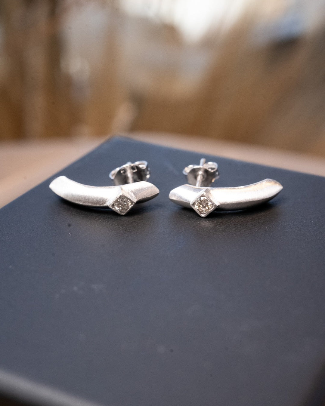 Brincos meia argola de ouro branco com diamantes. 1.9cm de altura e 0.4cm de largura. Peso 2.8g.