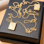 Escapulário de ouro amarelo com elos grumet e imagens do Sagrado Coração de Jesus e Nossa Senhora do Sagrado Coração.