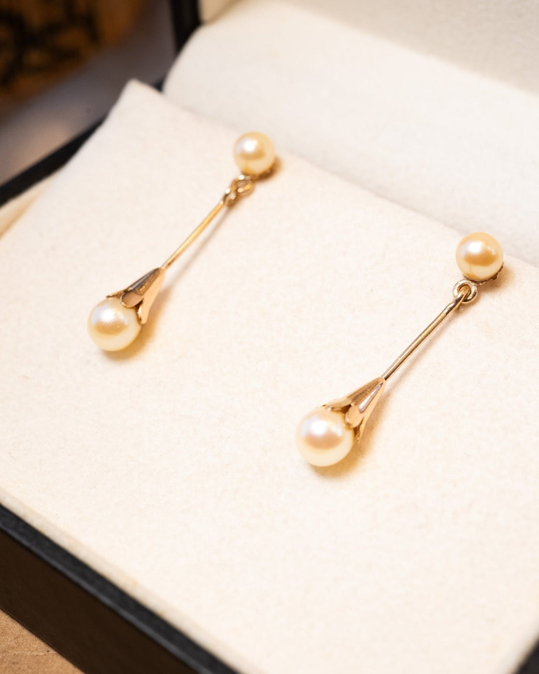 Brinco pendente de ouro rosê com pérolas douradas naturais. Mede 3.2cm x 0.6cm e pesa 2.9g.