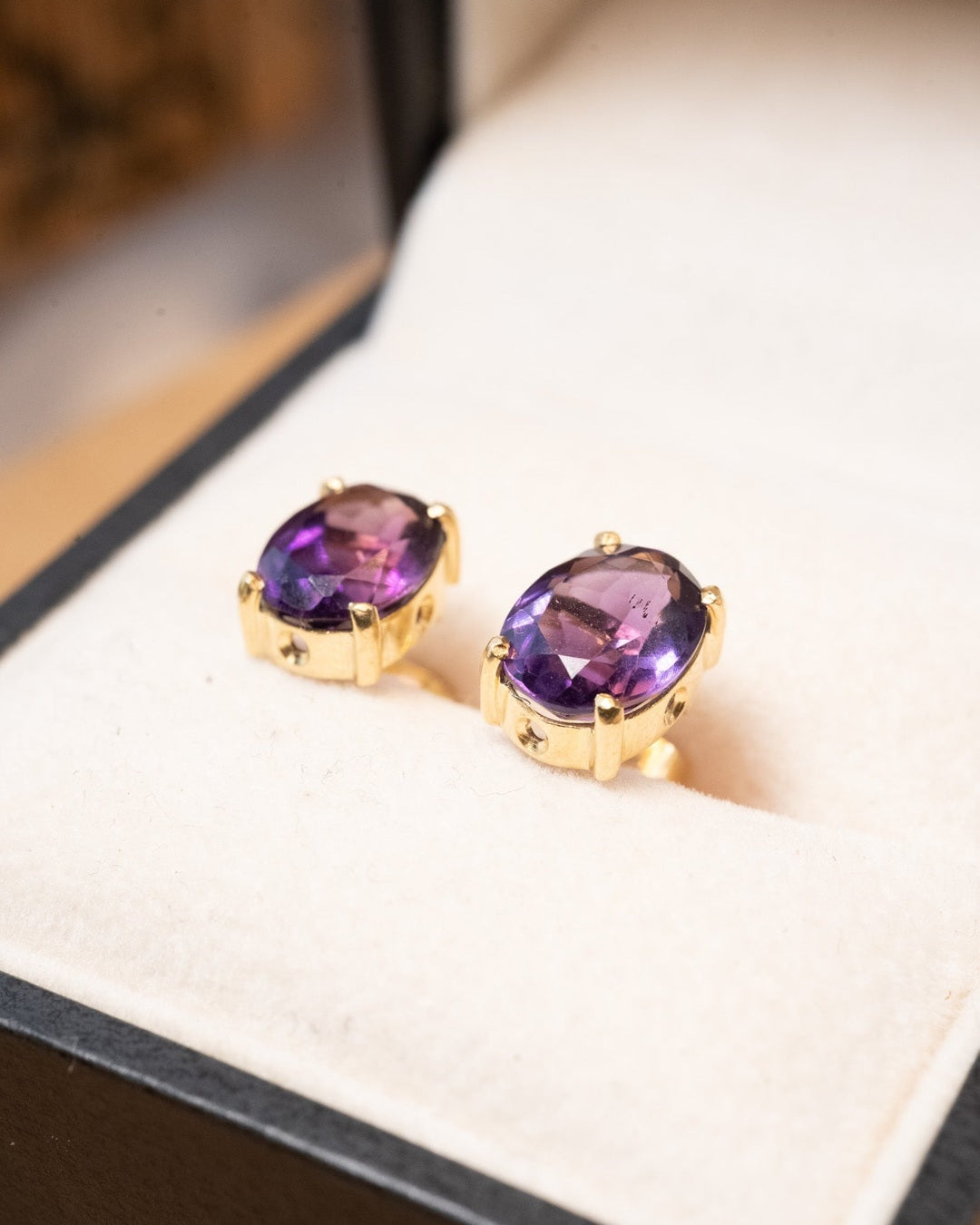 Brinco solitário stud de ouro amarelo com ametistas naturais. Mede 0.9cm x 0.7cm e pesa 2.6g.