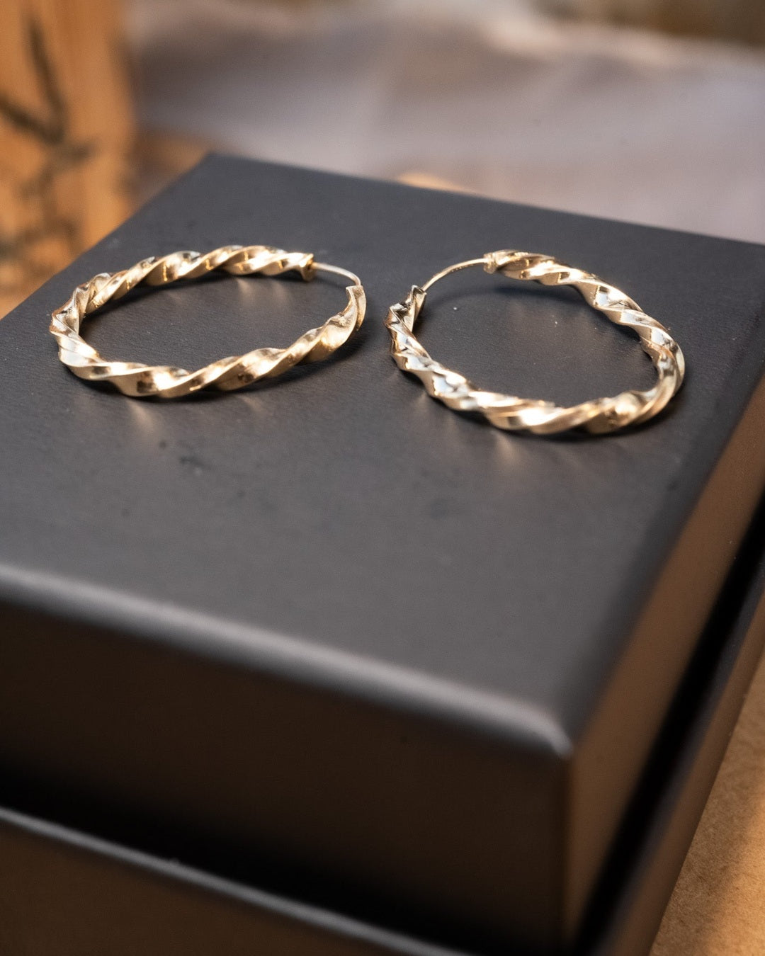 Brinco argolinha de ouro amarelo torcido com 2.7cm de comprimento e 0.3cm de largura. Peso 2.4g.