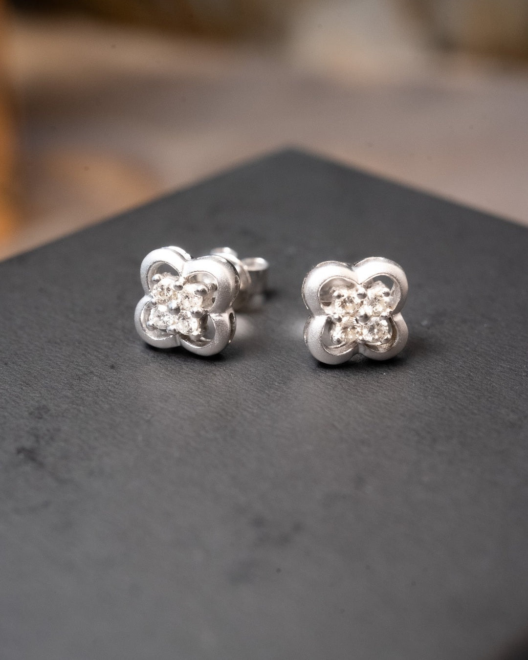 Brinco flor em ouro branco com diamantes. Diâmetro de 0.8cm e peso de 2.7g.