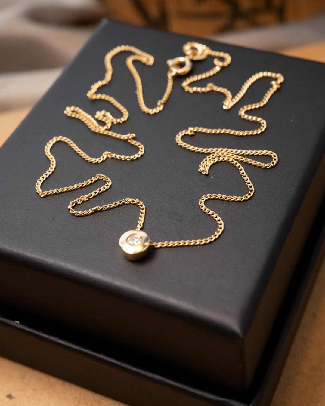 Corrente de ouro amarelo com elos grumet e ponto de luz de diamante de 0.12ct. 45cm de comprimento e 0.1cm de espessura. Peso 2.5g.