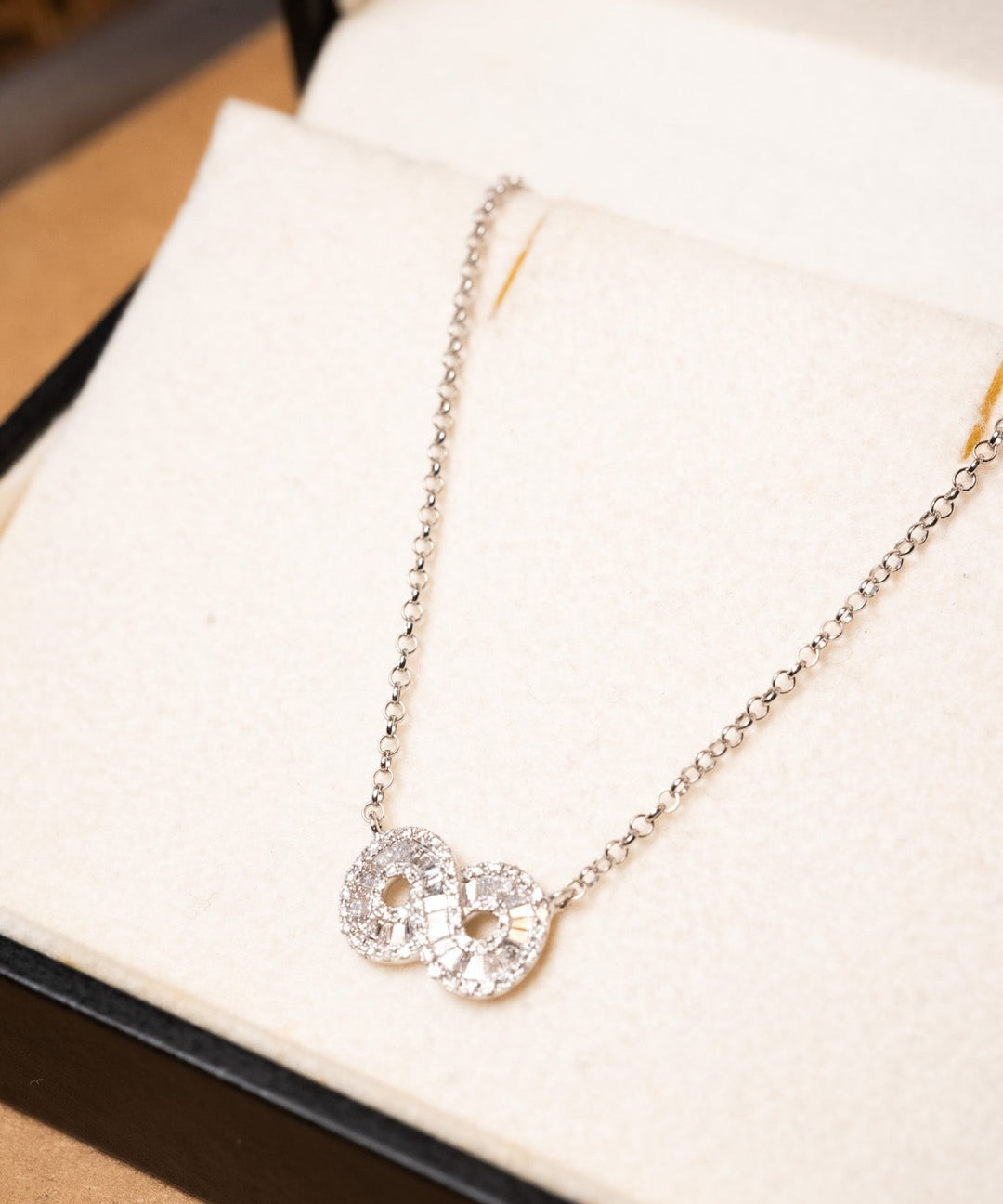 Colar infinito de ouro branco com elos portugueses e cravejado de diamantes. Medidas: 50 cm de comprimento e 0.2 cm de espessura. Peso: 3.2g.