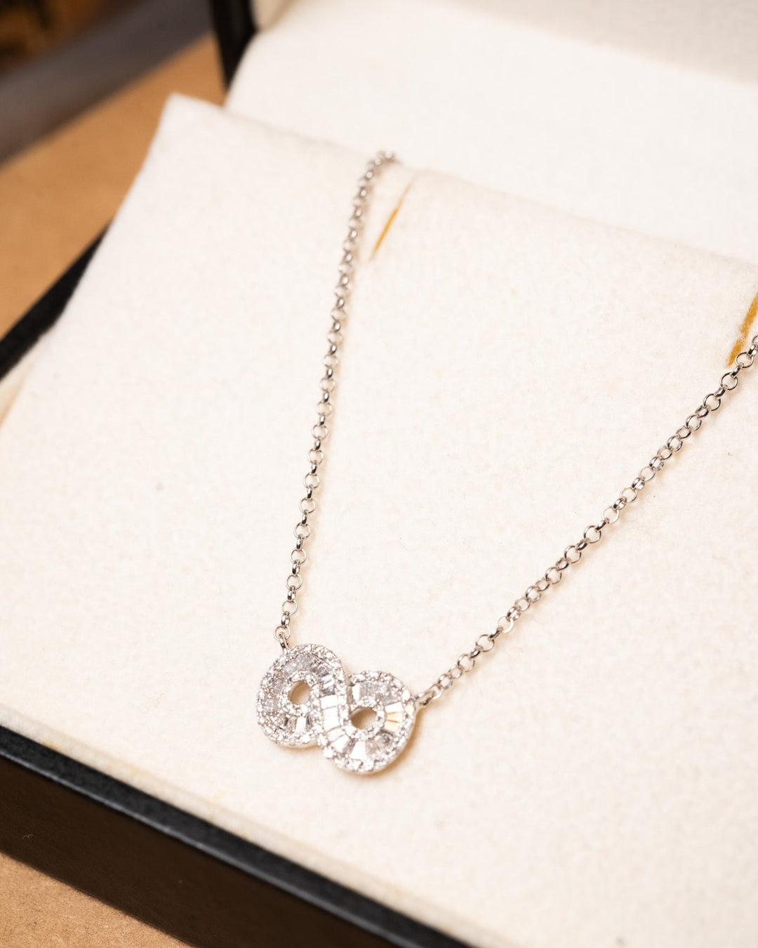 Colar infinito de ouro branco com elos portugueses e cravejado de diamantes. Medidas: 50 cm de comprimento e 0.2 cm de espessura. Peso: 3.2g.