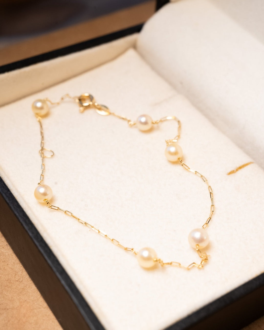 Pulseira de ouro amarelo com pérolas douradas naturais de 0.5mm e 20cm de comprimento. Peso 1.5g.