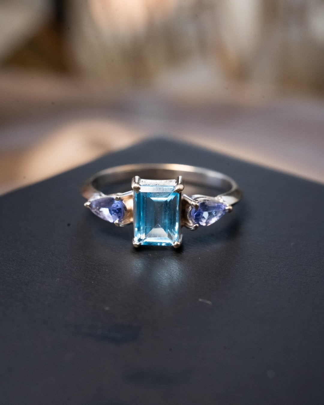 Anel de ouro branco com topazio azul e turmalinas. Largura 0.8cm. Aro 17.5. Peso 2.2g.