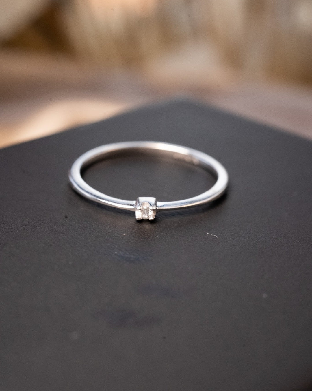 Anel solitário de ouro branco com diamante de 0.03 pontos. Largura 0.2cm. Aro 19. Peso 1.2g.