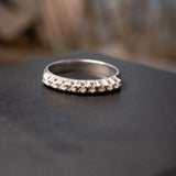 Meia aliança de ouro branco com 9 diamantes de 0.02 pontos cada. Aro 14. Peso 2.1g.