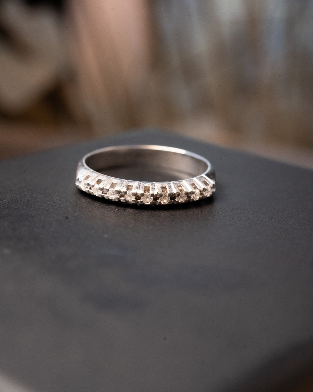 Meia aliança de ouro branco com 9 diamantes de 0.02 pontos cada. Aro 14. Peso 2.1g.