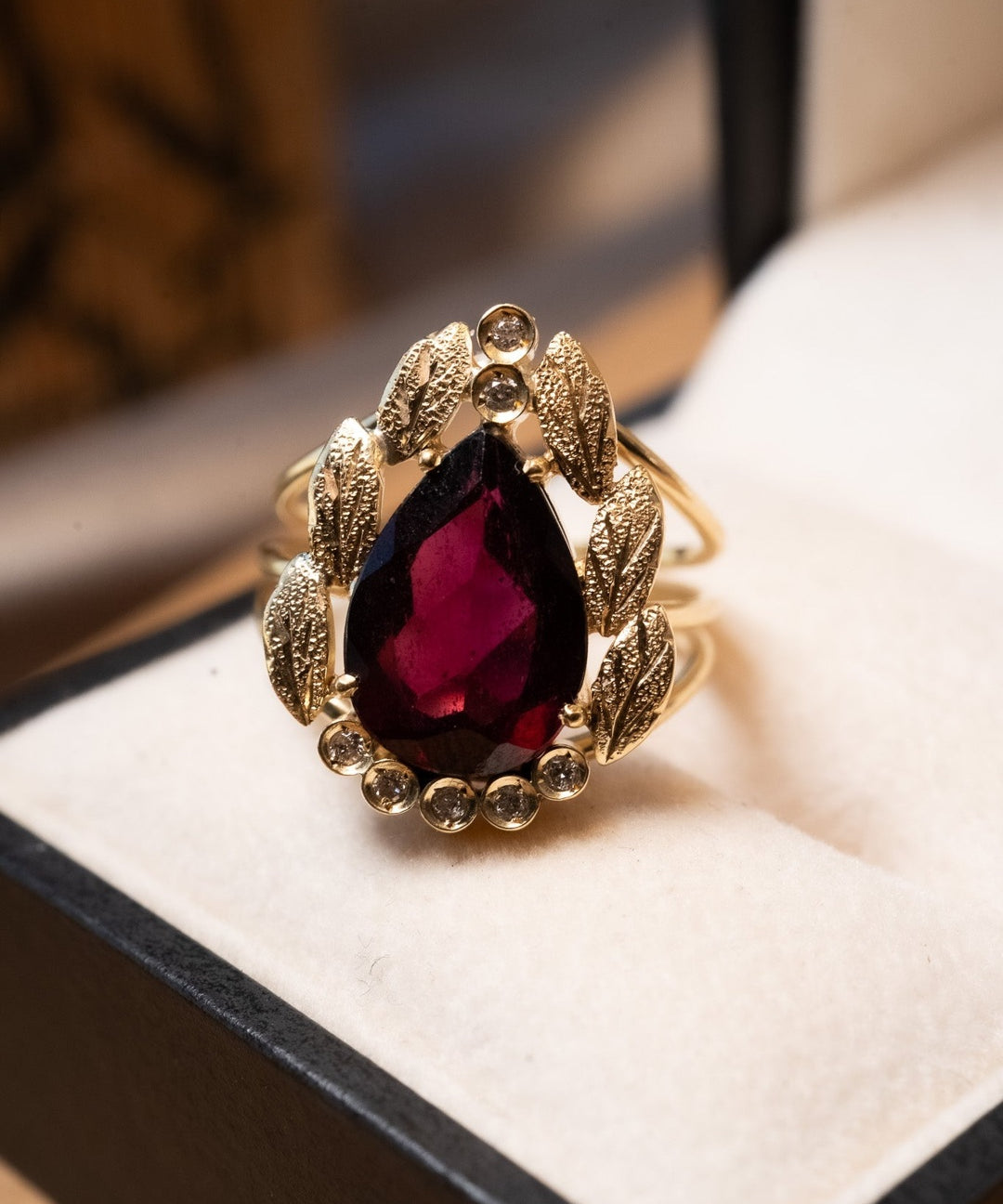 Anel de ouro amarelo com granada gota de 3.5cts e diamantes. Aro 16. Peso 5.8g.