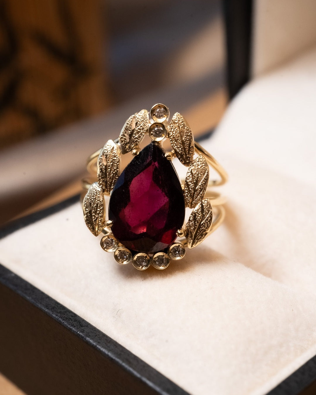 Anel de ouro amarelo com granada gota de 3.5cts e diamantes. Aro 16. Peso 5.8g.