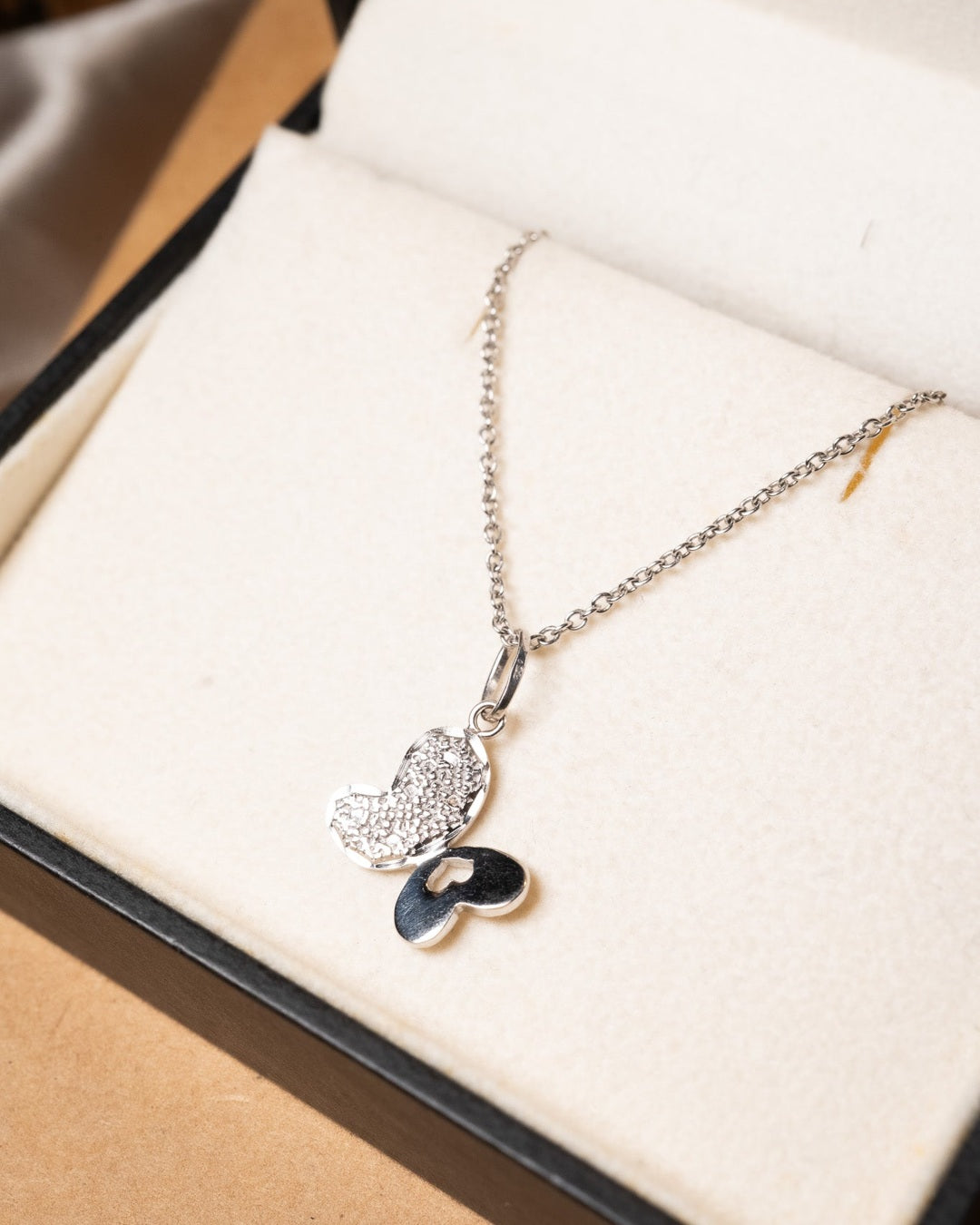 Pingente borboleta de ouro branco com 2.0cm de comprimento e 2.4cm de largura pesando 1.2g.