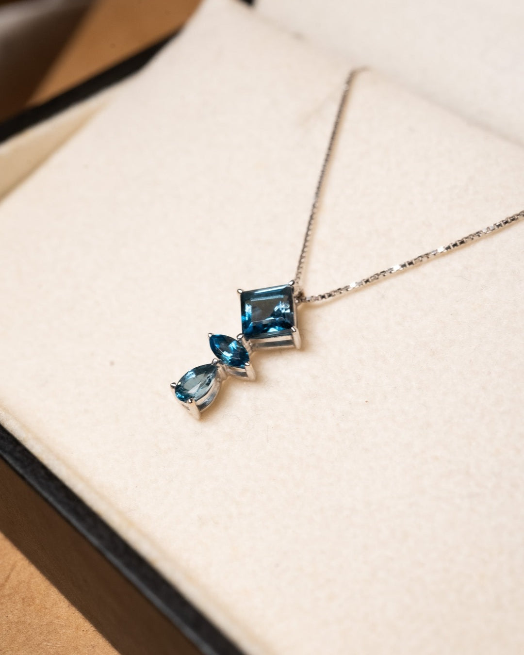 Pingente de ouro branco com topázios azuis London. Mede 1.7cm x 0.8cm e pesa 0.9g.