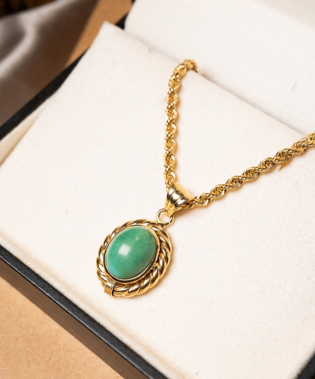 Pingente de ouro amarelo com jade cabochão. Mede 2.9cm por 1.6cm e pesa 4.5g.
