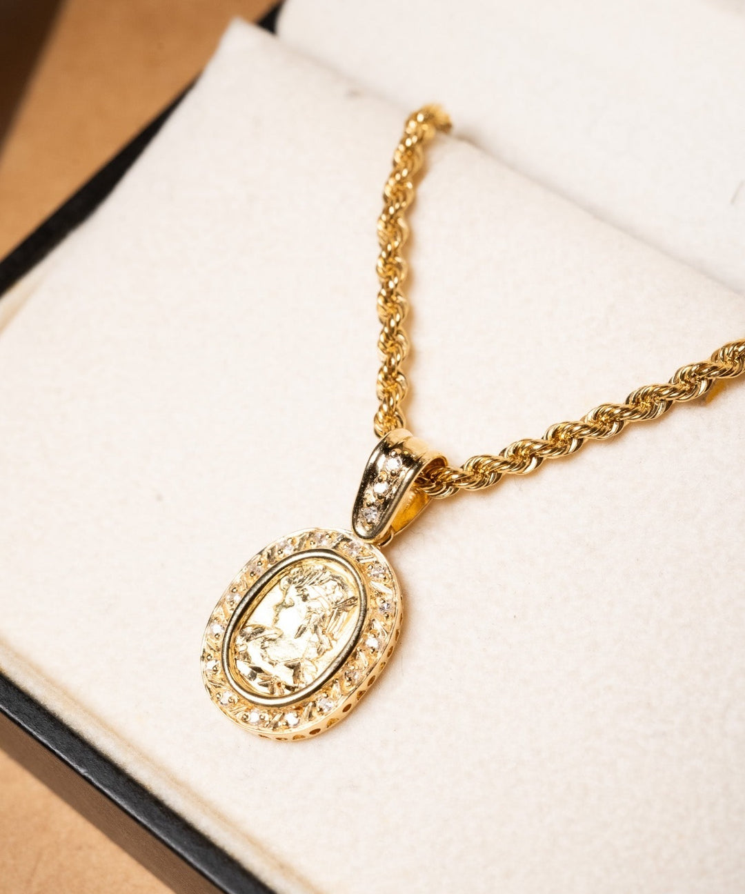Pingente camafeu de ouro amarelo com diamantes. Mede 2.7cm por 1.4cm e pesa 3.7g.