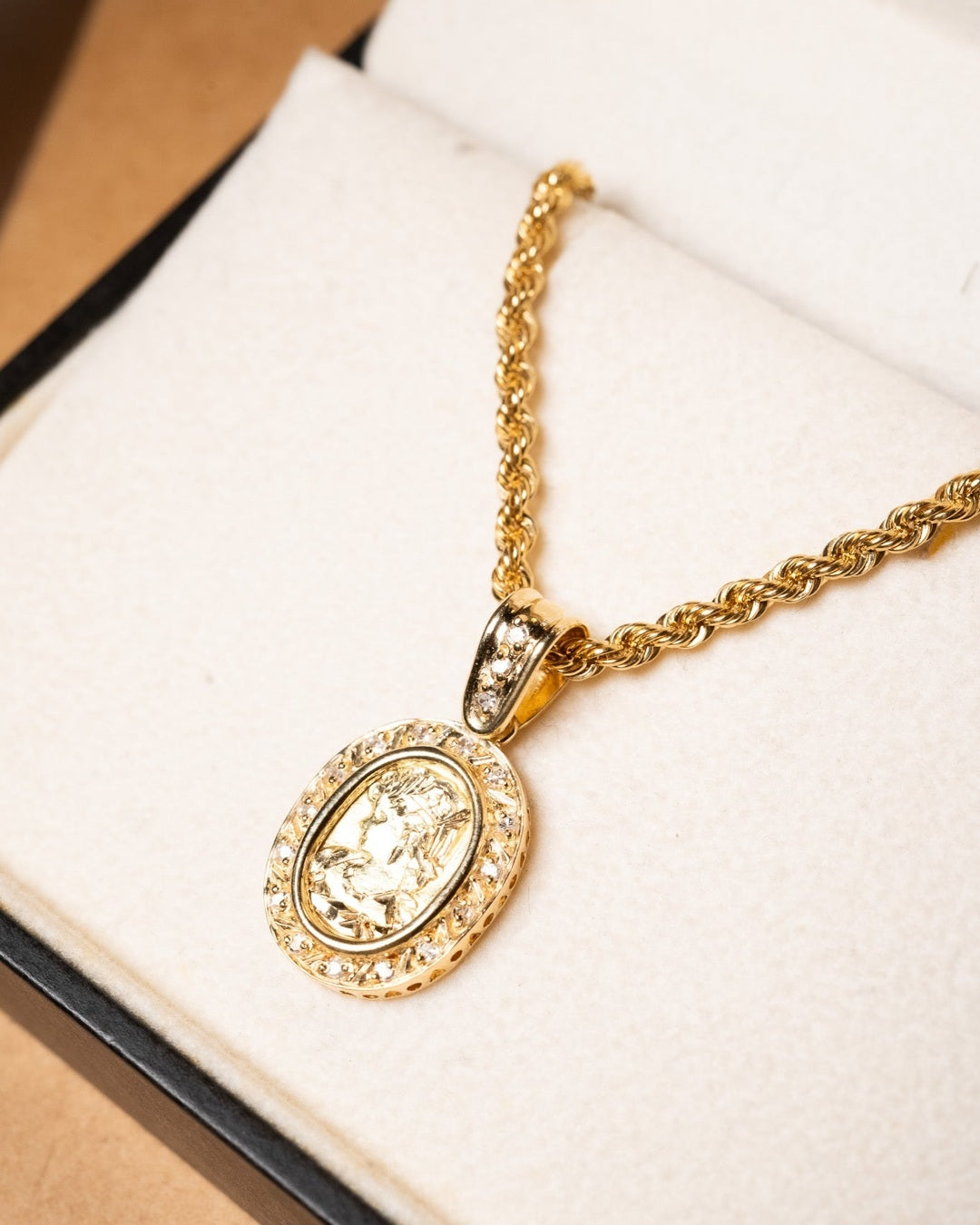 Pingente camafeu de ouro amarelo com diamantes. Mede 2.7cm por 1.4cm e pesa 3.7g.