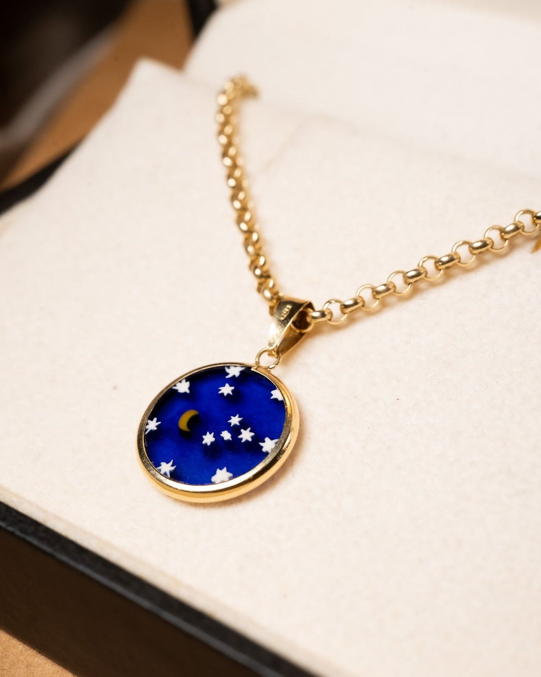 Pingente estelar de ouro amarelo com esmalte. Medidas 2.3cm x 1.6cm. Peso 1.2g.